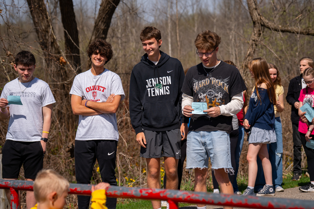High school students smiling as they wait for elementary students