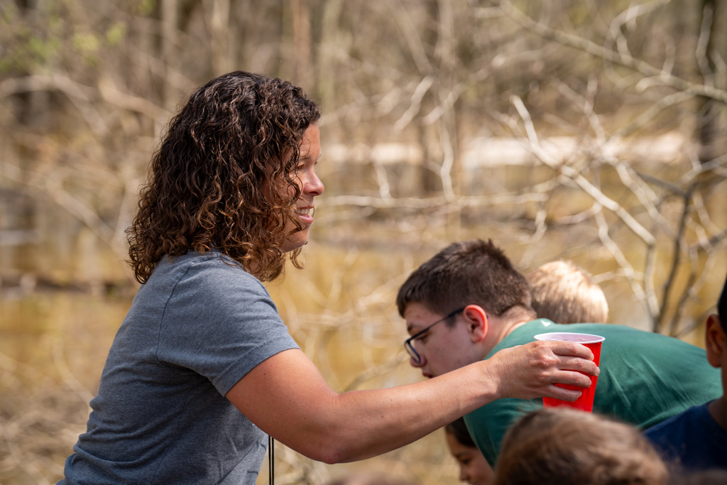 Teacher handing out cups with salmon in them