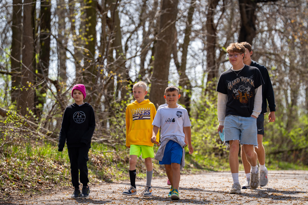 Elementary students and high school students walking to river
