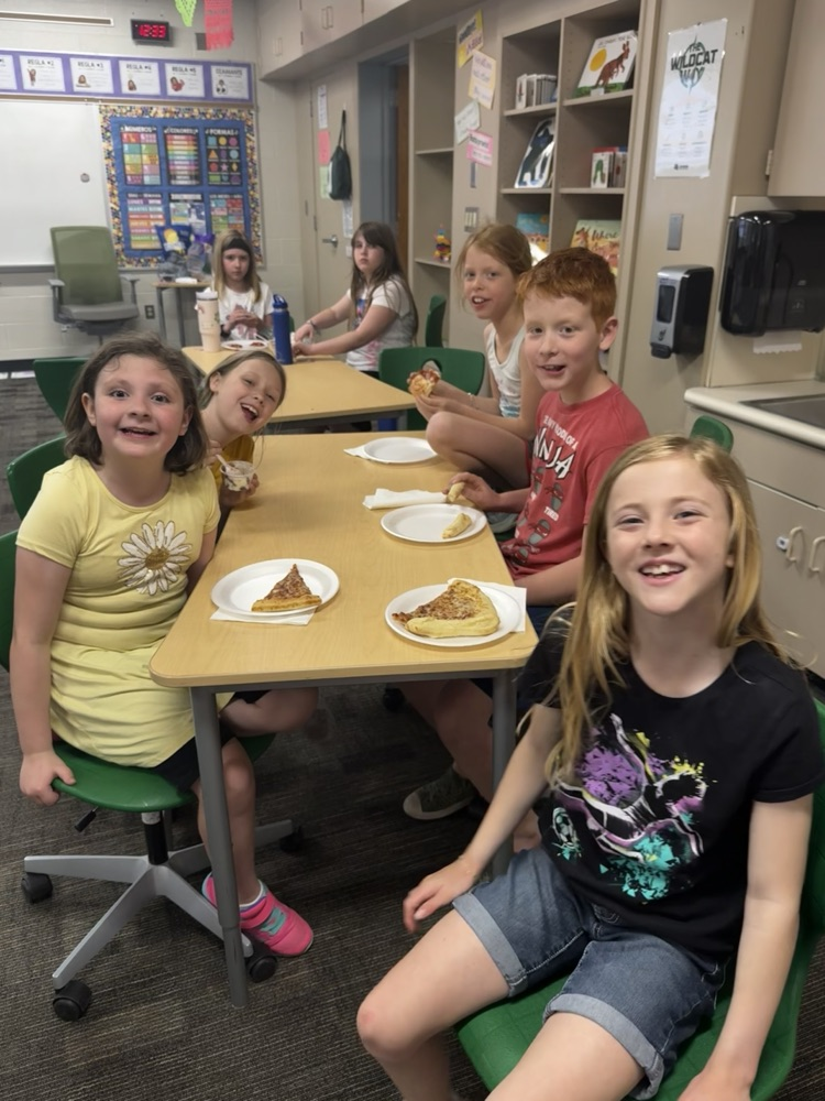 students smiling and eating pizza