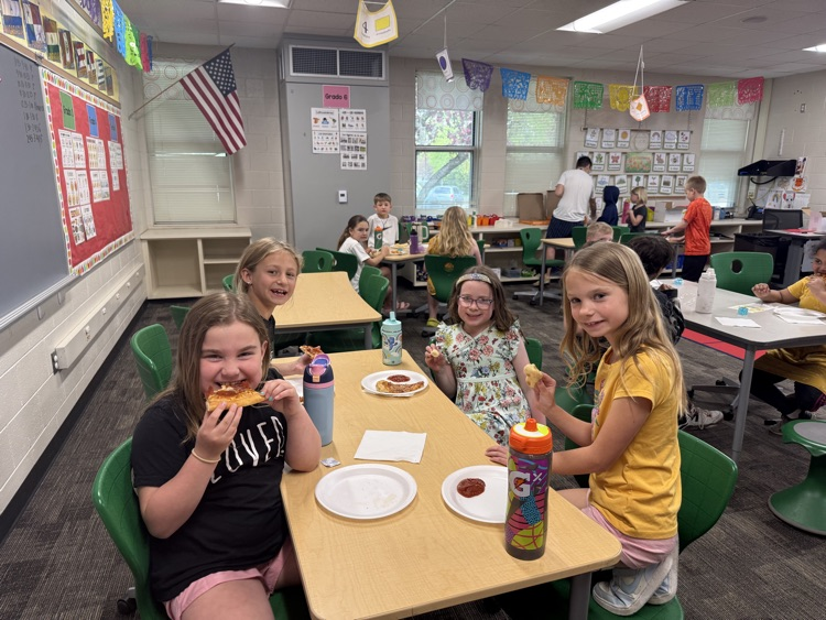 students smiling and eating pizza