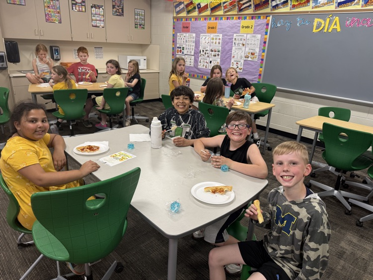 students smiling and eating pizza