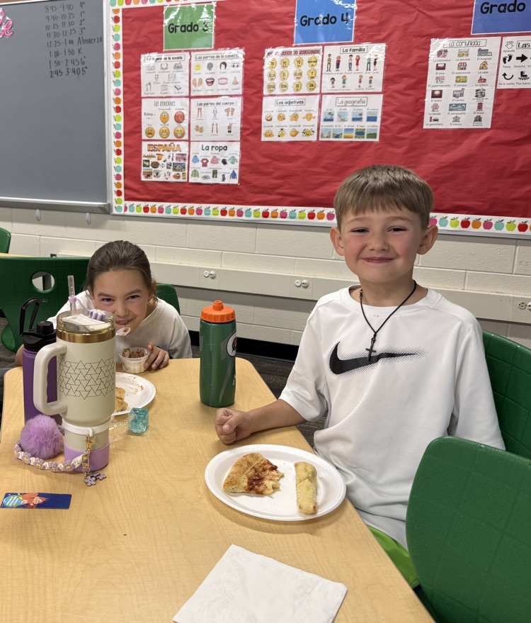 students smiling and eating pizza