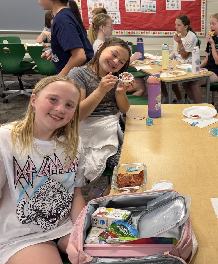 students smiling and eating pizza