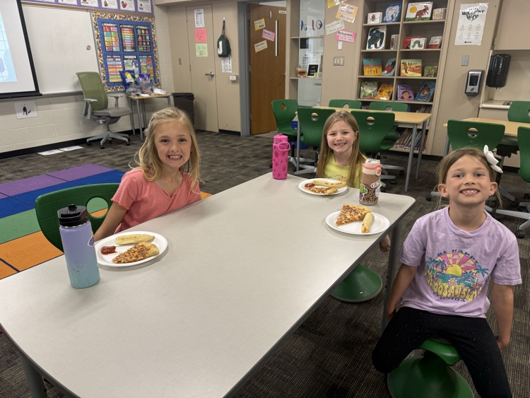students smiling and eating pizza