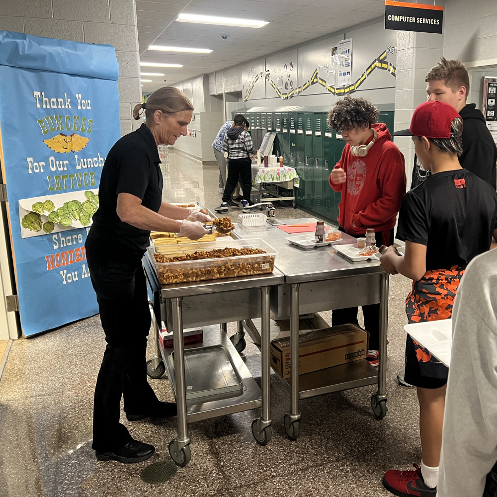Ms. Jan serves secondary students lunch.