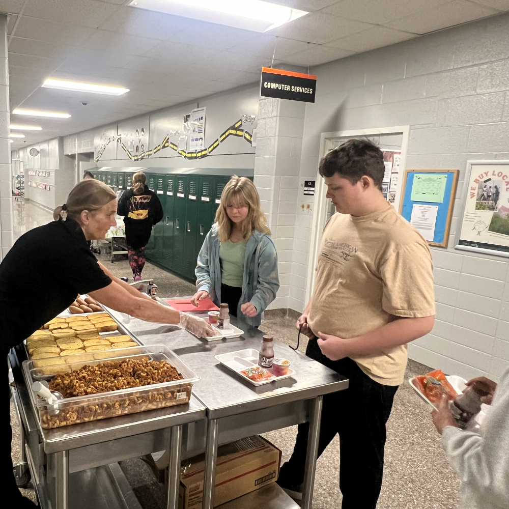 Ms. Jan serves secondary students lunch.