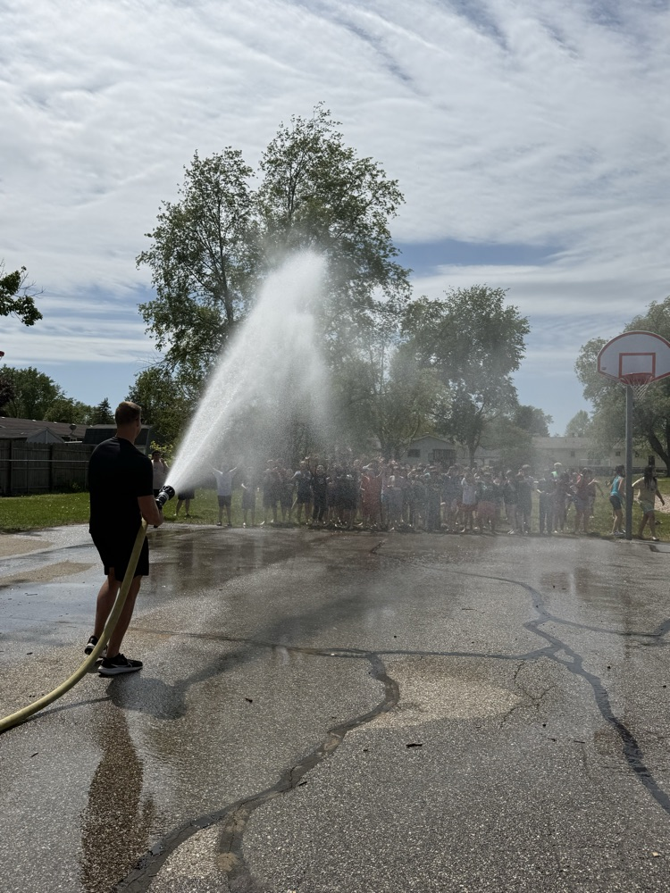 teacher spraying students with hose