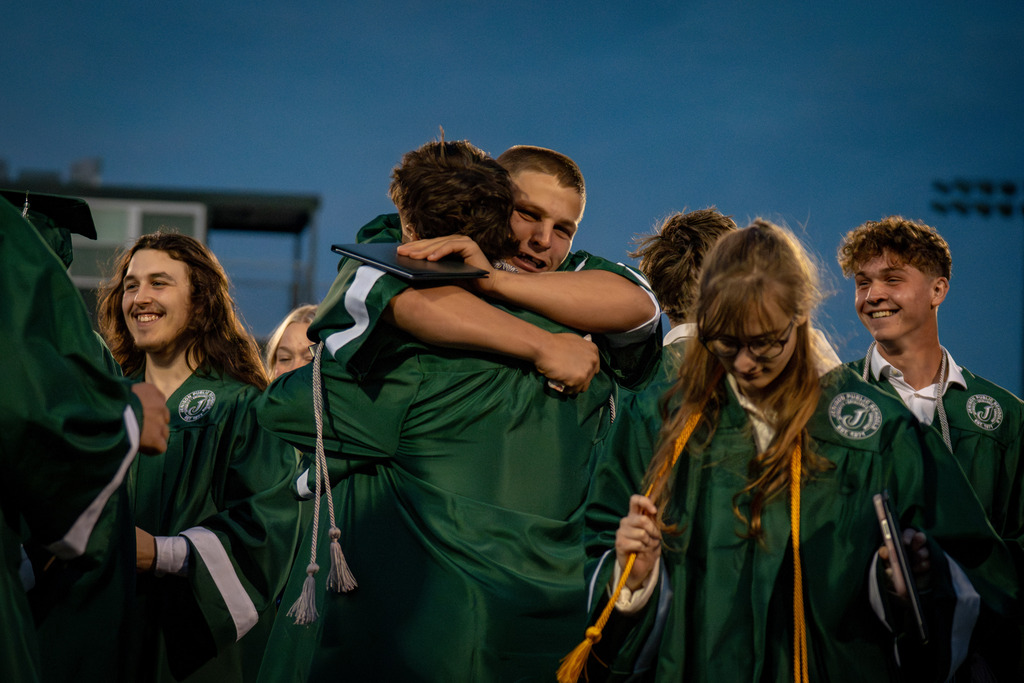 graduates hugging