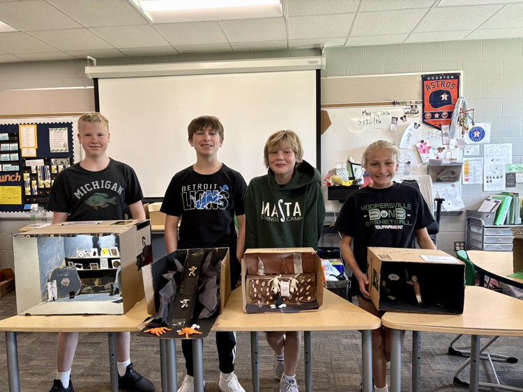sixth graders showing off final book club projects
