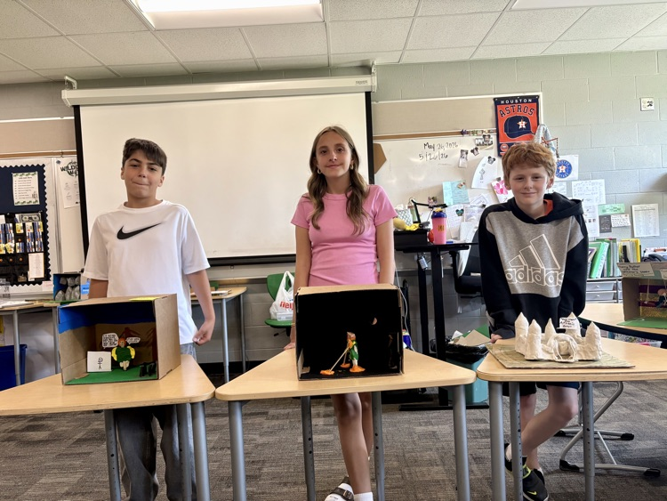 sixth graders showing off final book club projects