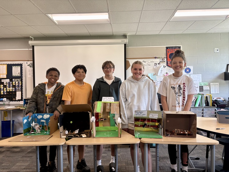 sixth graders showing off final book club projects
