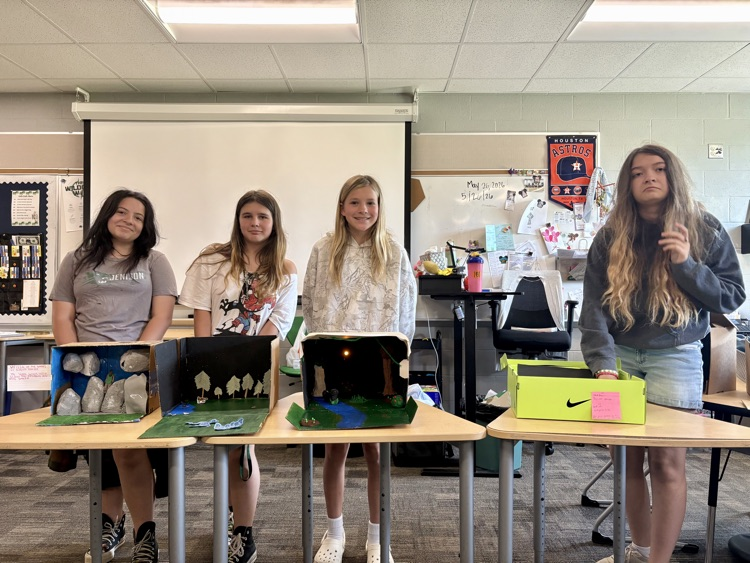 sixth graders showing off final book club projects