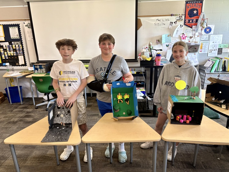 sixth graders showing off final book club projects