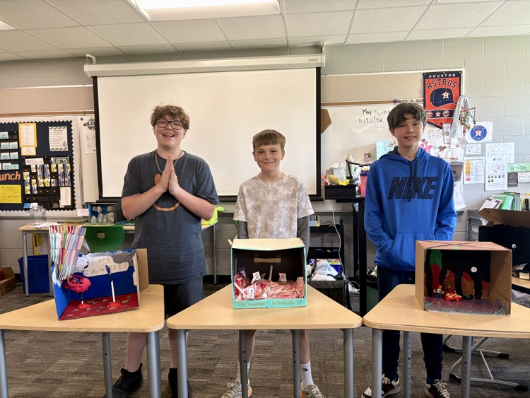 sixth graders showing off final book club projects