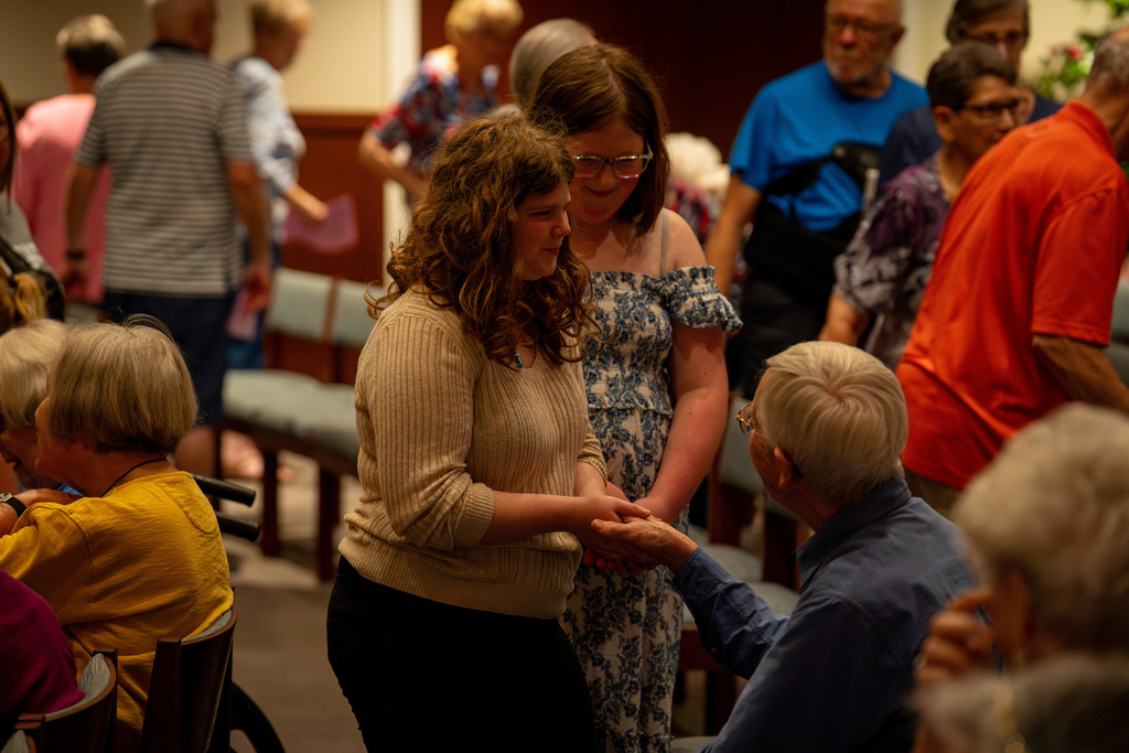Girls choir member shaking hands with members of crowd