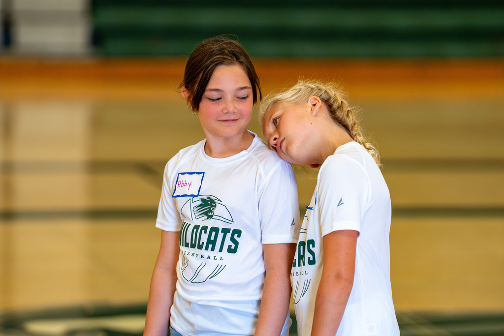 Volleyball players smiling and lean on each other