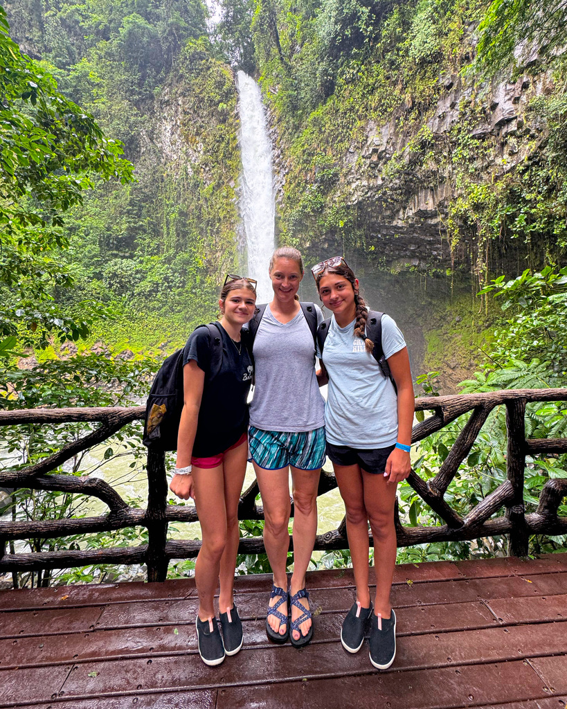 Junior high students pose in front of waterfall in Costa Rica