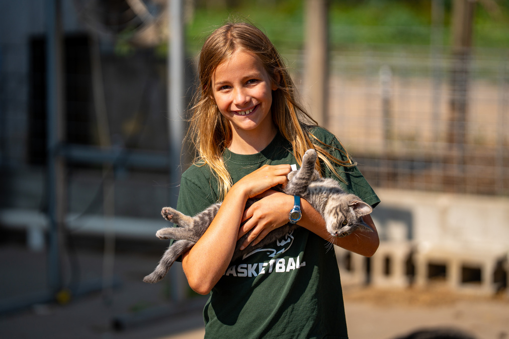 JIA student smiling with cat