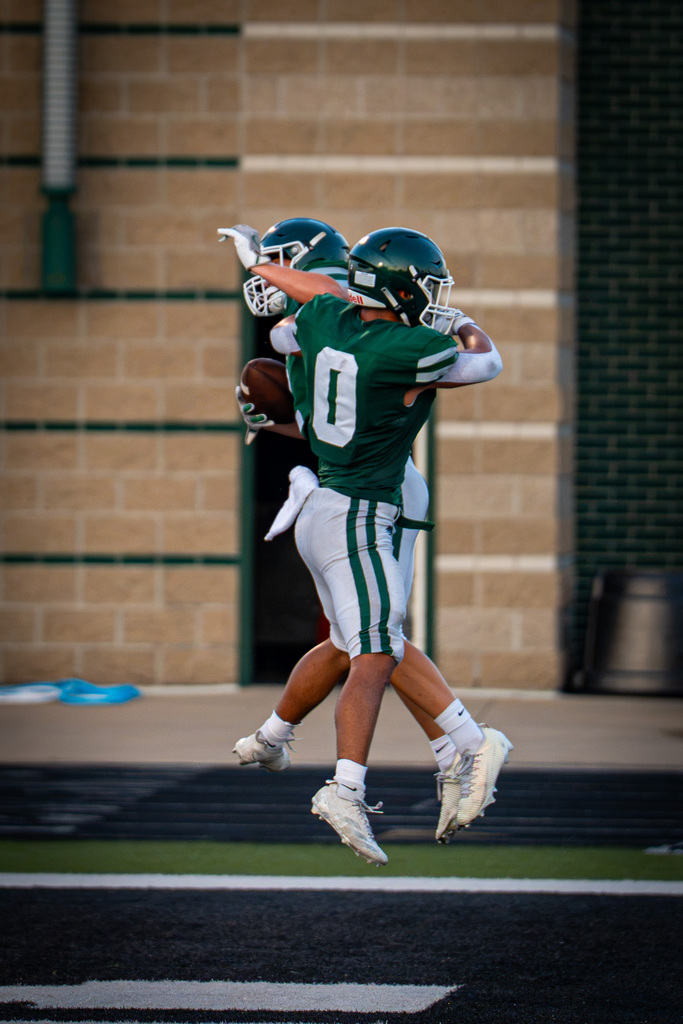 Players jumping in air to celebrate touchdown