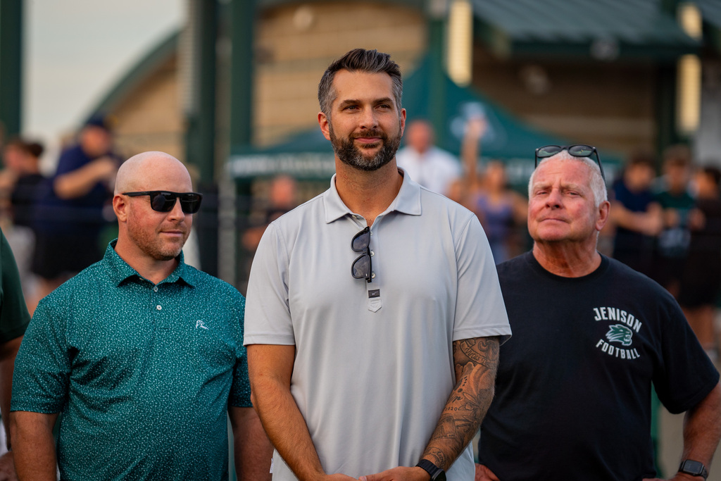 Former football players smiling at game