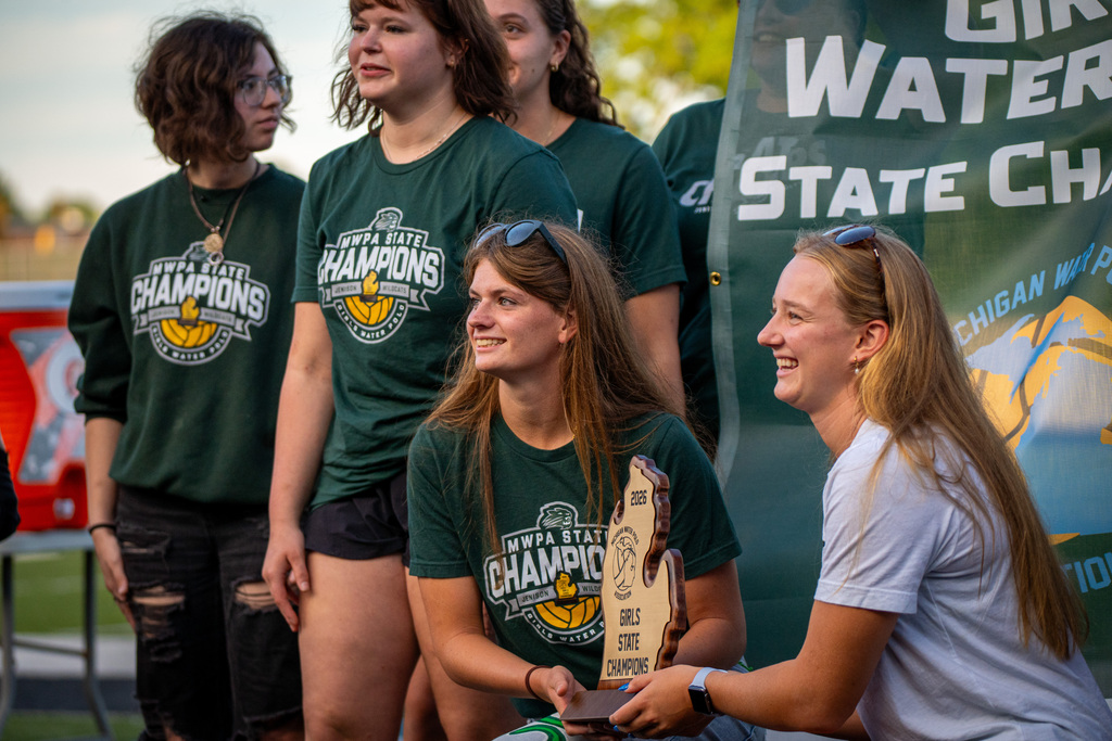 Girls water polo team holding trophy