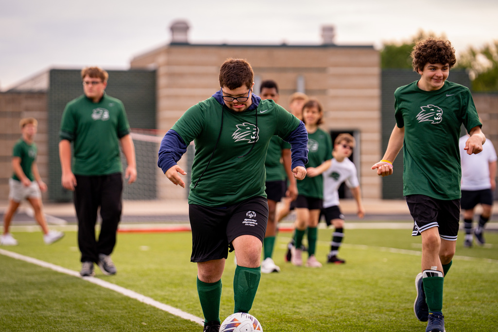 Student dribbling soccer ball