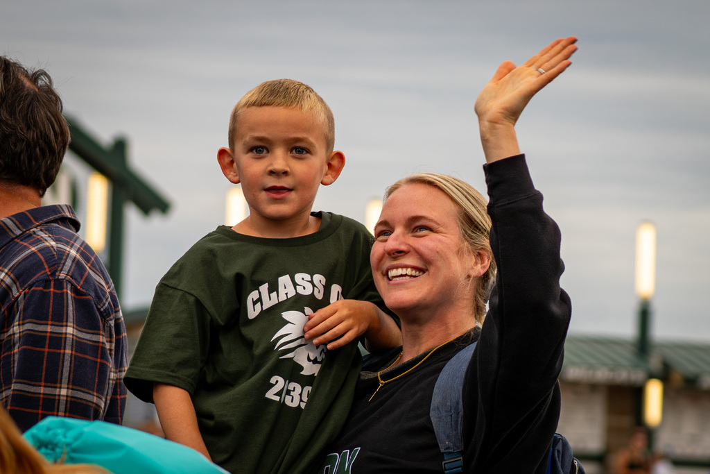 Parent and student smiling and waving