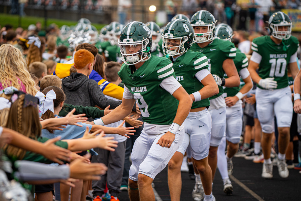 Football players high fiving in the Kid Cats game tunnel