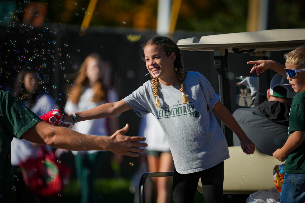Student sharing bubbles with parade crowd