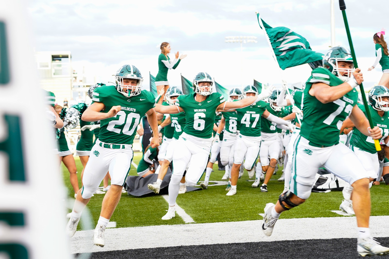 Football players running on field
