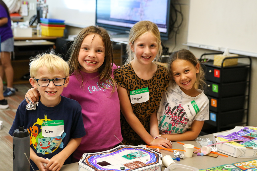 3 girls and one boy smiling and laughing for a photo