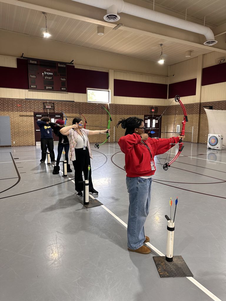 a line of students practicing archery