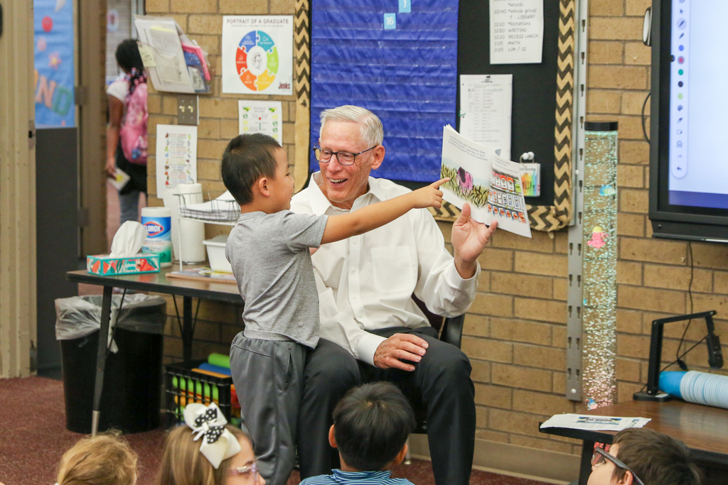 Sen. Dave radar smiling at a student who is pointing at the book