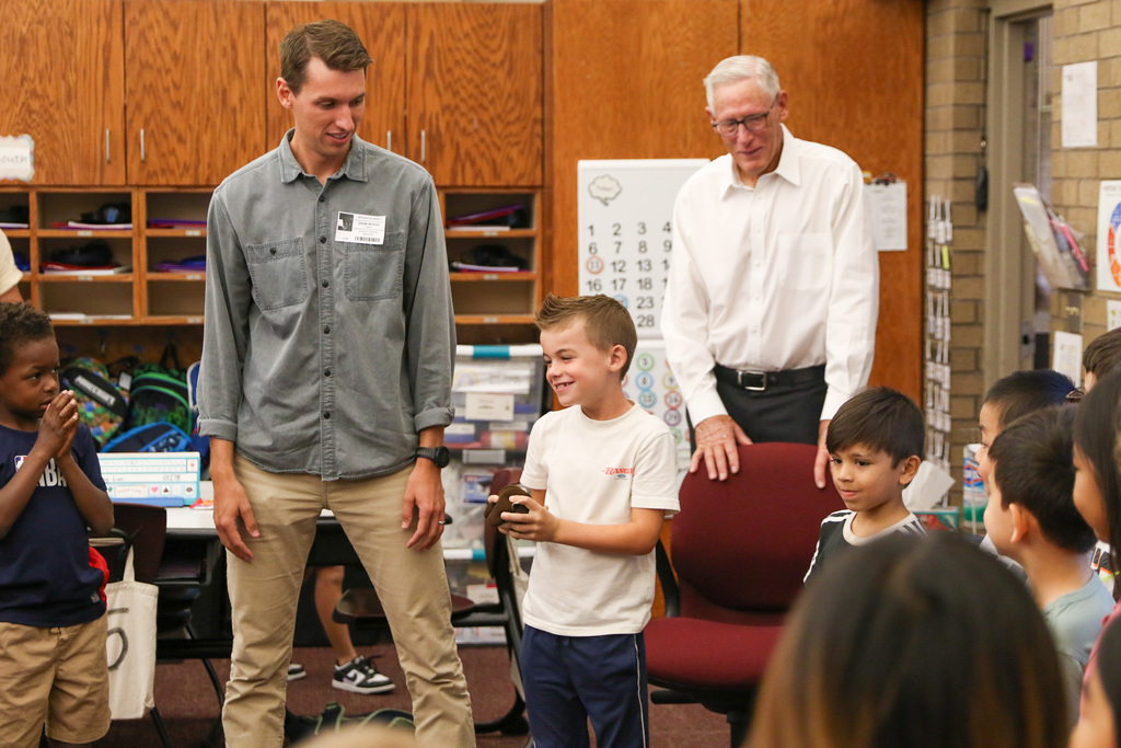student smiling with his dad next to him