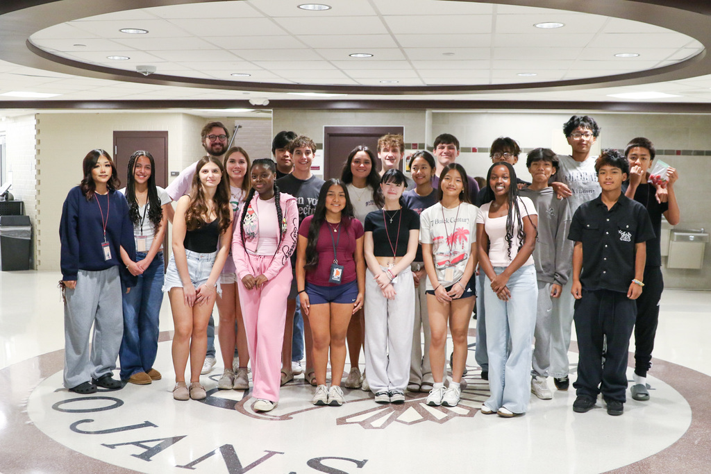 AVID class and teacher posing for group photo in hallway of Jenks High School