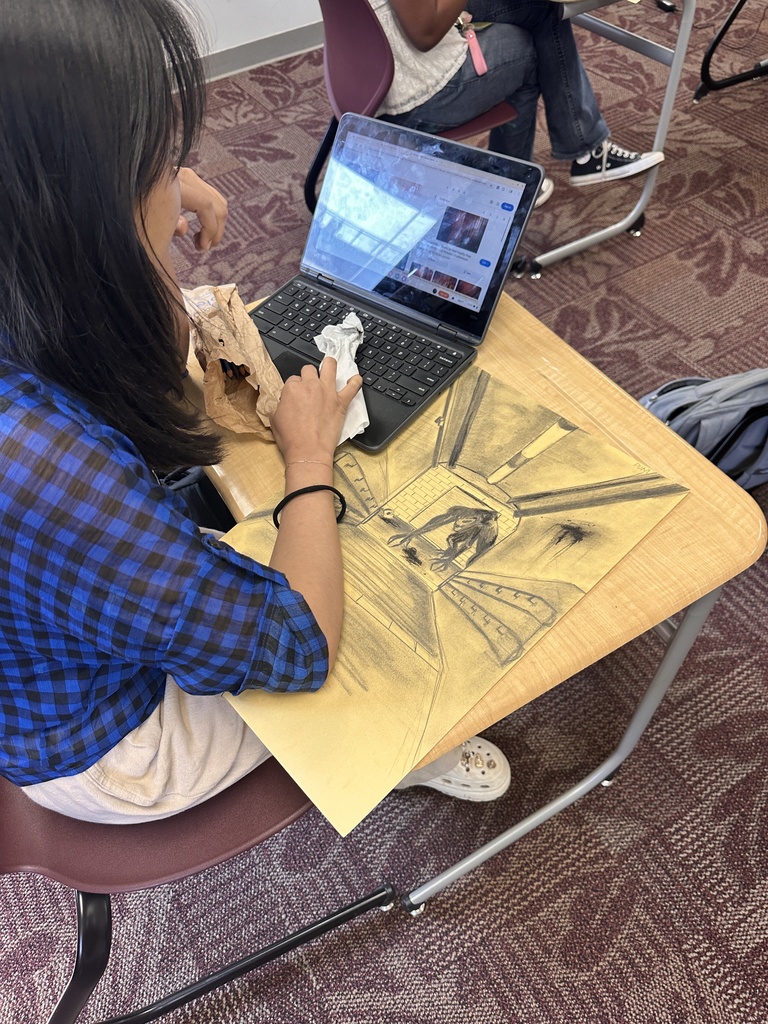 A student working on a drawing of a movie poster