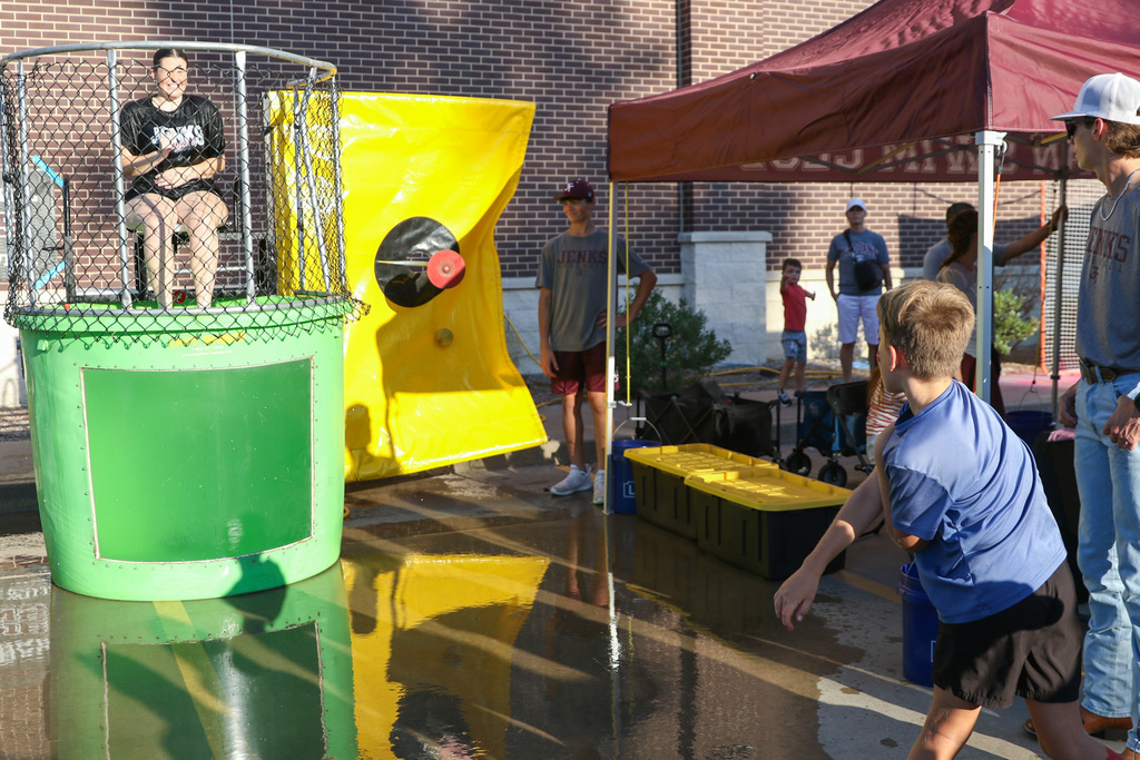 kid throws ball at the dunk tank and misses