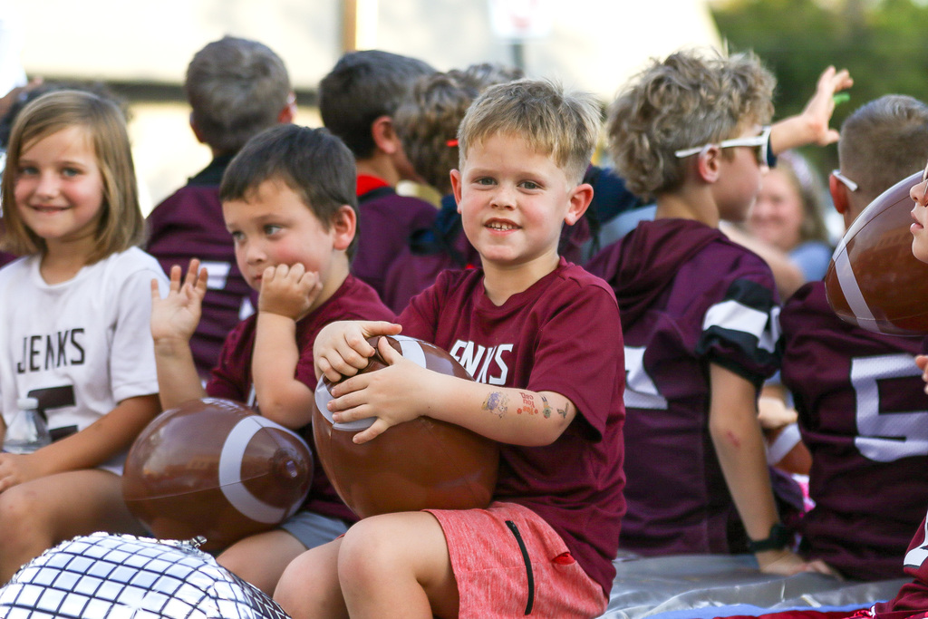 boy with a football balloon on a float smiling at the camera