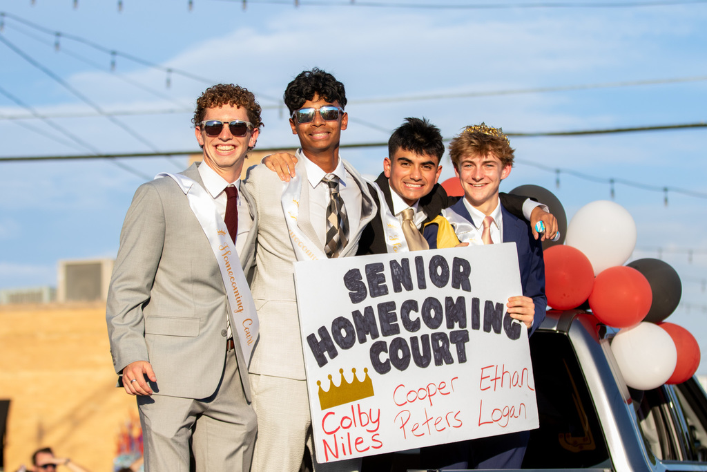 4 boys on the senior homecoming court smiling at the camera