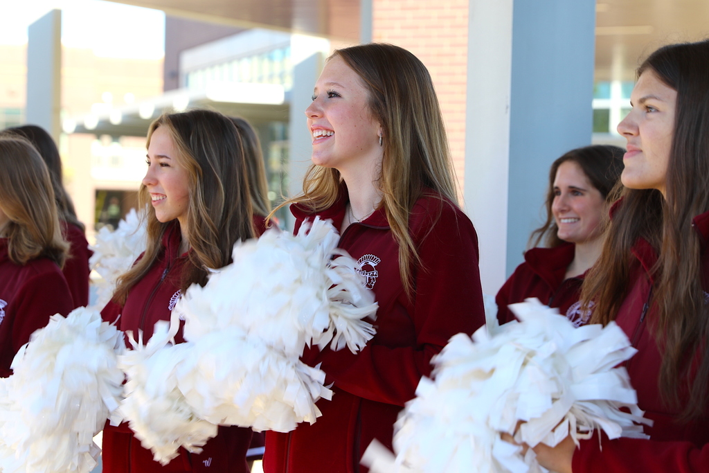 cheerleader smiling with pom poms in hand