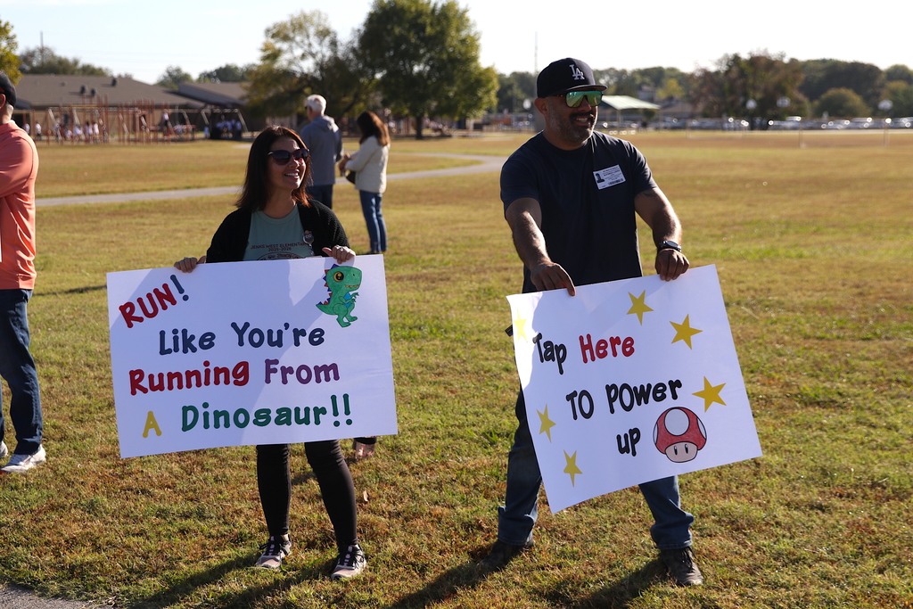 parents holding signs to encourage runners during jog-a-thon
