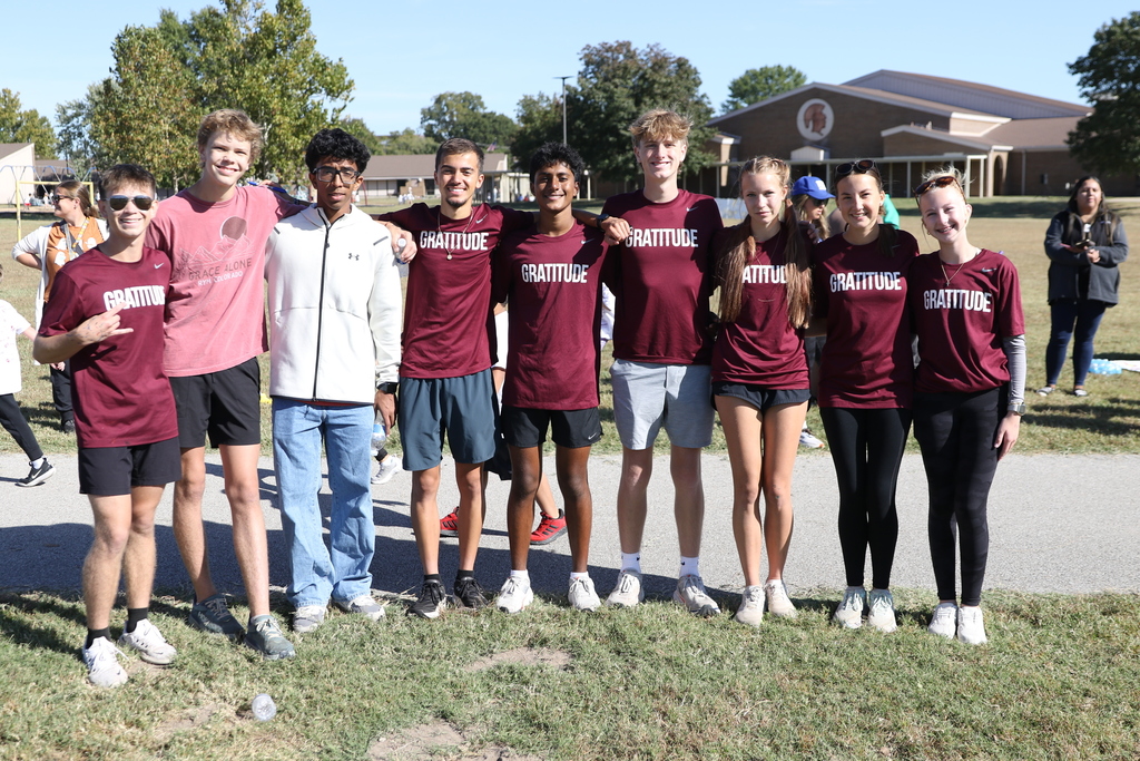 Jenks cross country team members volunteering at jog-a-thon and posing for photo