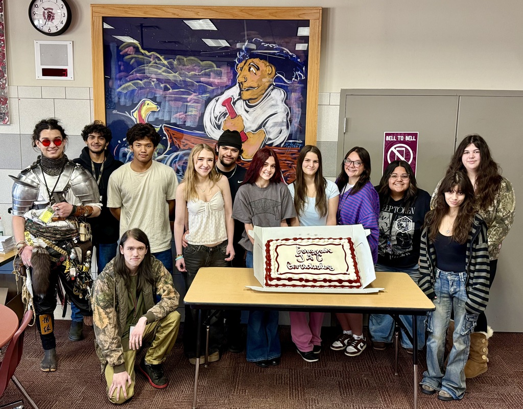 A group of students with a cake.