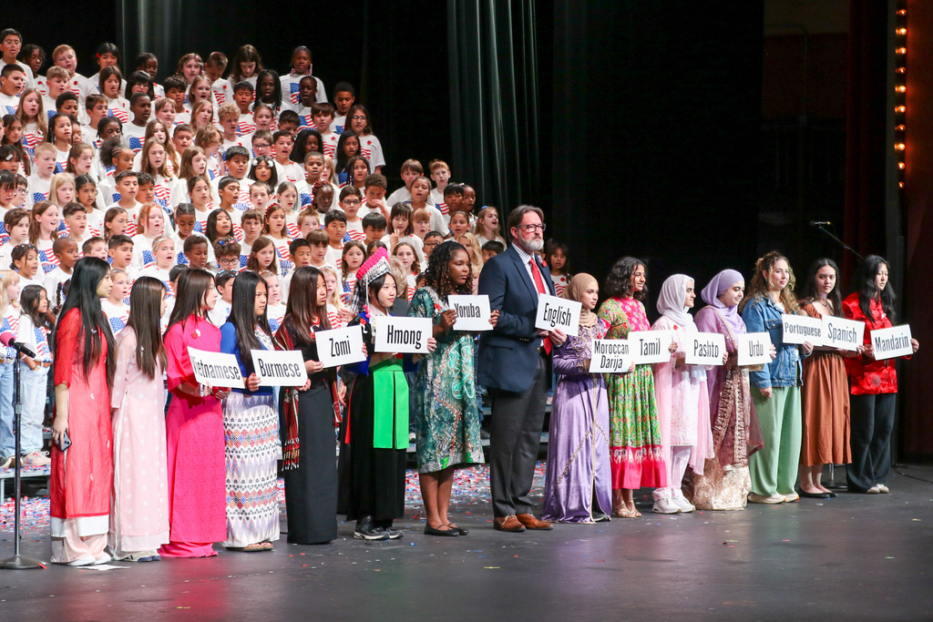 principal and high school students with different languages wrote on signs