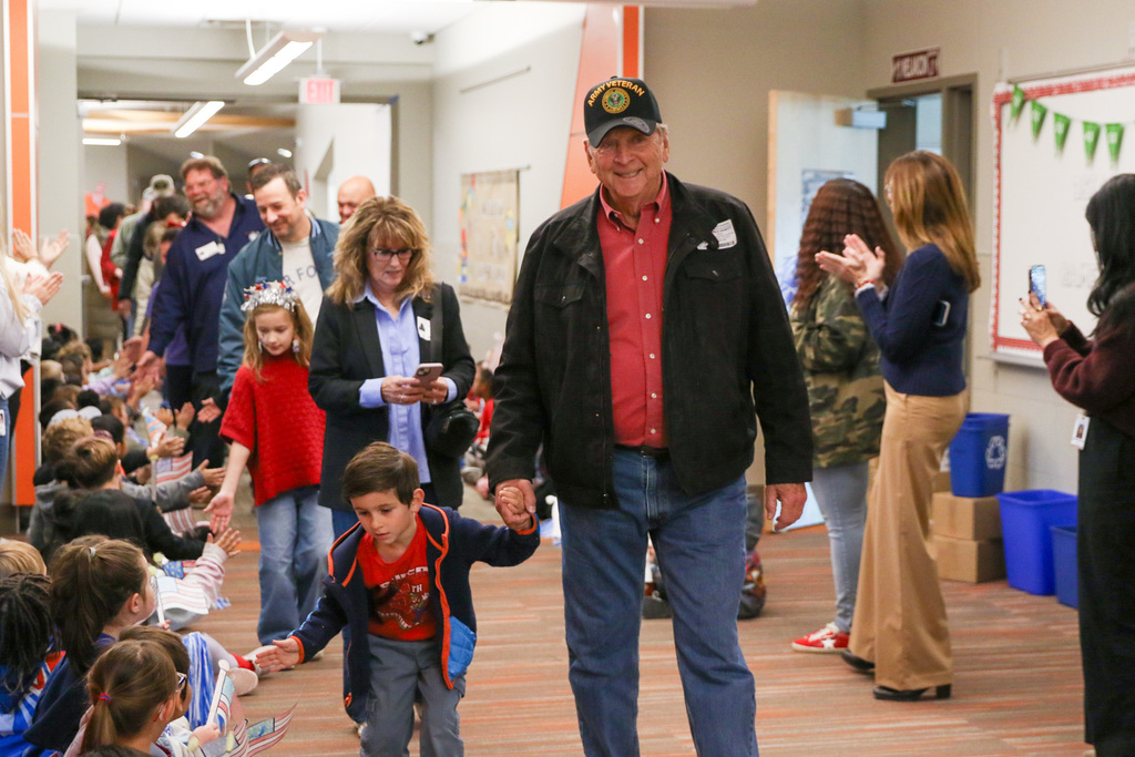 grandpa and grand child walking in the northwest veterans parade