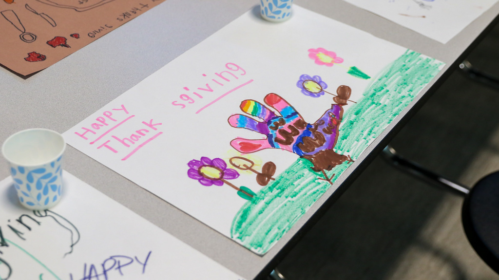 handmade placemat with a hand turkey and flowers and it says happy thanksgiving