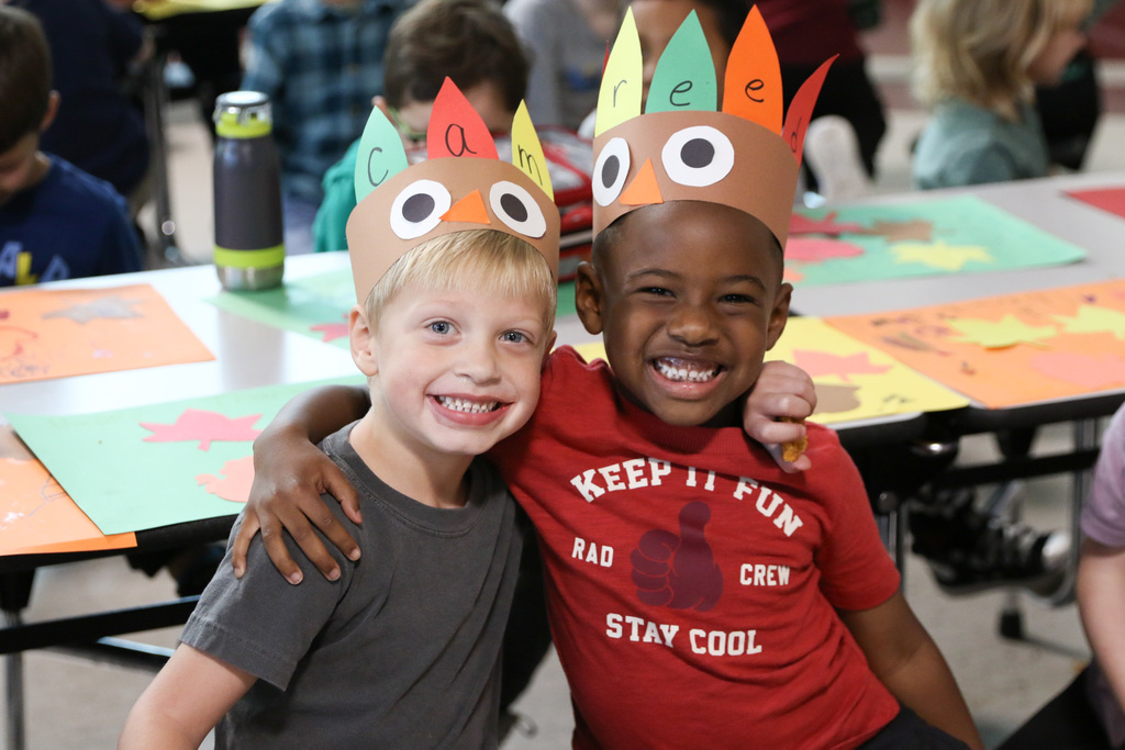 two boys with their ams around eachother smiling