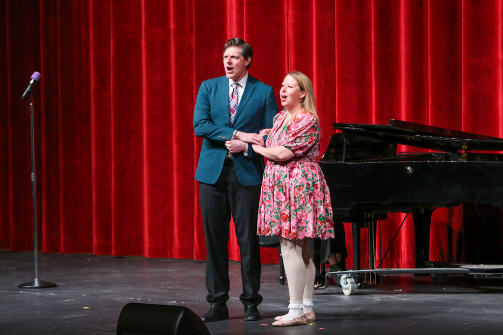 a duo singing and holding hands