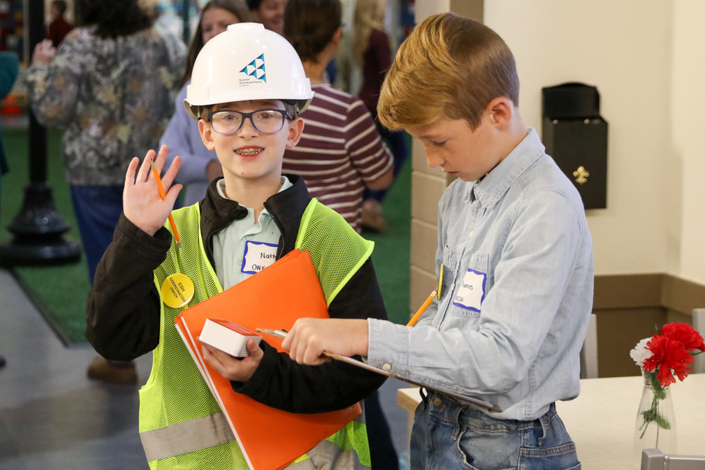 two boys checking meters and one is smiling and waving